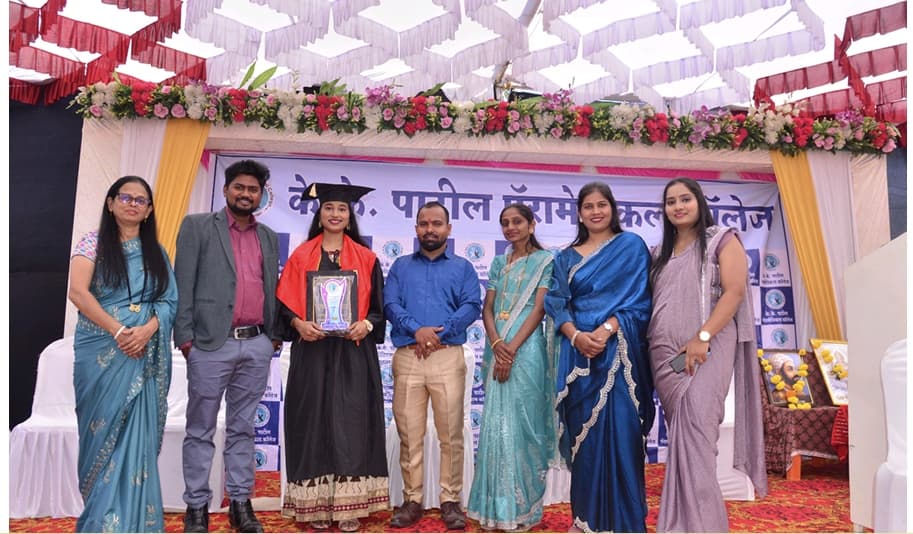 Female graduate candidate receiving convocation plaque on stage