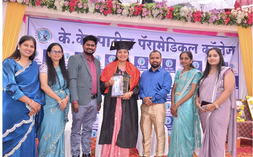 Graduate candidate in pink saree receiving convocation award on stage