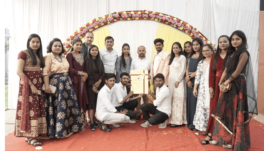 Faculty members and graduates group photo in front of floral archway
